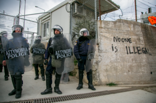 Riot police outside the Moria detention centre during a protest on 24 March