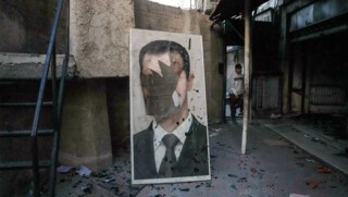 A defaced portrait of Bashar al-Assad in a ransacked government security facility in Damascus, 8 December 2024. Photo © Rami al-Sayed / AFP / Getty.
