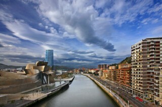 Winter skies over the Guggenheim Museum and River Nervión, Bilbao, January 2016. Photo © Hercules Milas / Alamy