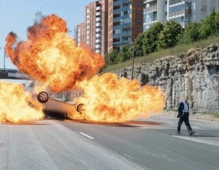 Kenneth Branagh walks away from (or is it towards?) an exploding car. 