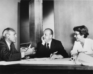 Philip Johnson, Mies van der Rohe and Phyllis Lambert in front of an image of the Seagram building model (1955).