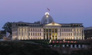The moon rises behind the Presidential Palace in Tbilisi
